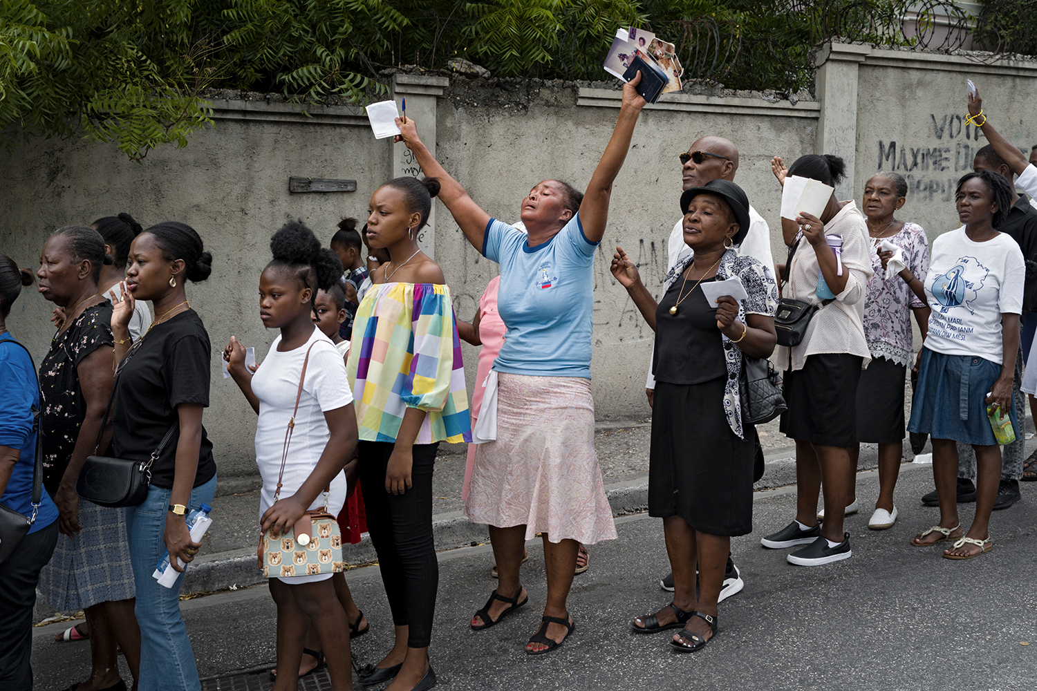 Une procession catholique parcourt une rue qui s’étend dans un quartier non pris par un gang. Les prières appellent à la paix et à la sécurité. 