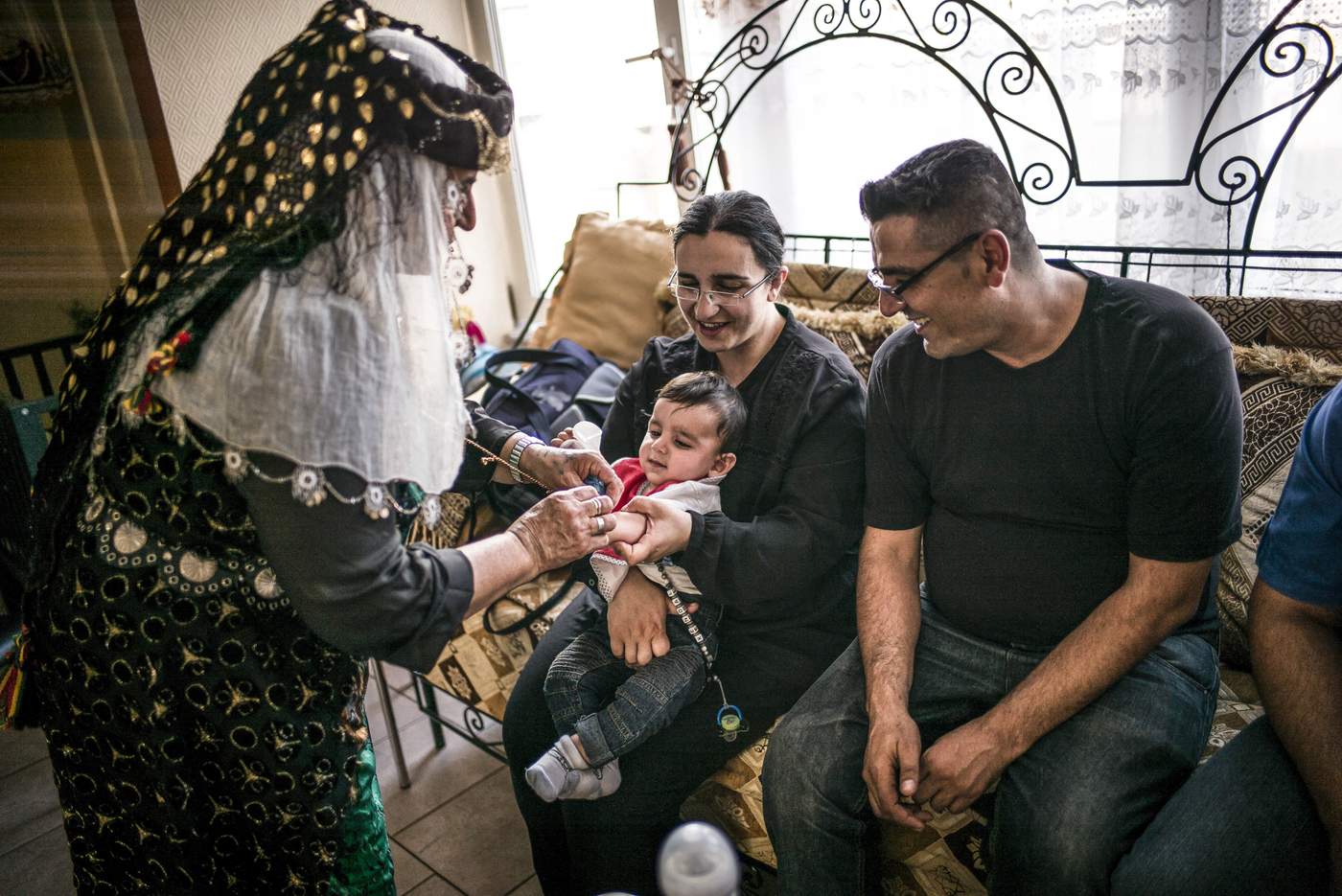 Suleyman Agirman, responsable du centre de Droixhe, en famille. Son fils reçoit un bracelet aux couleurs kurdes.