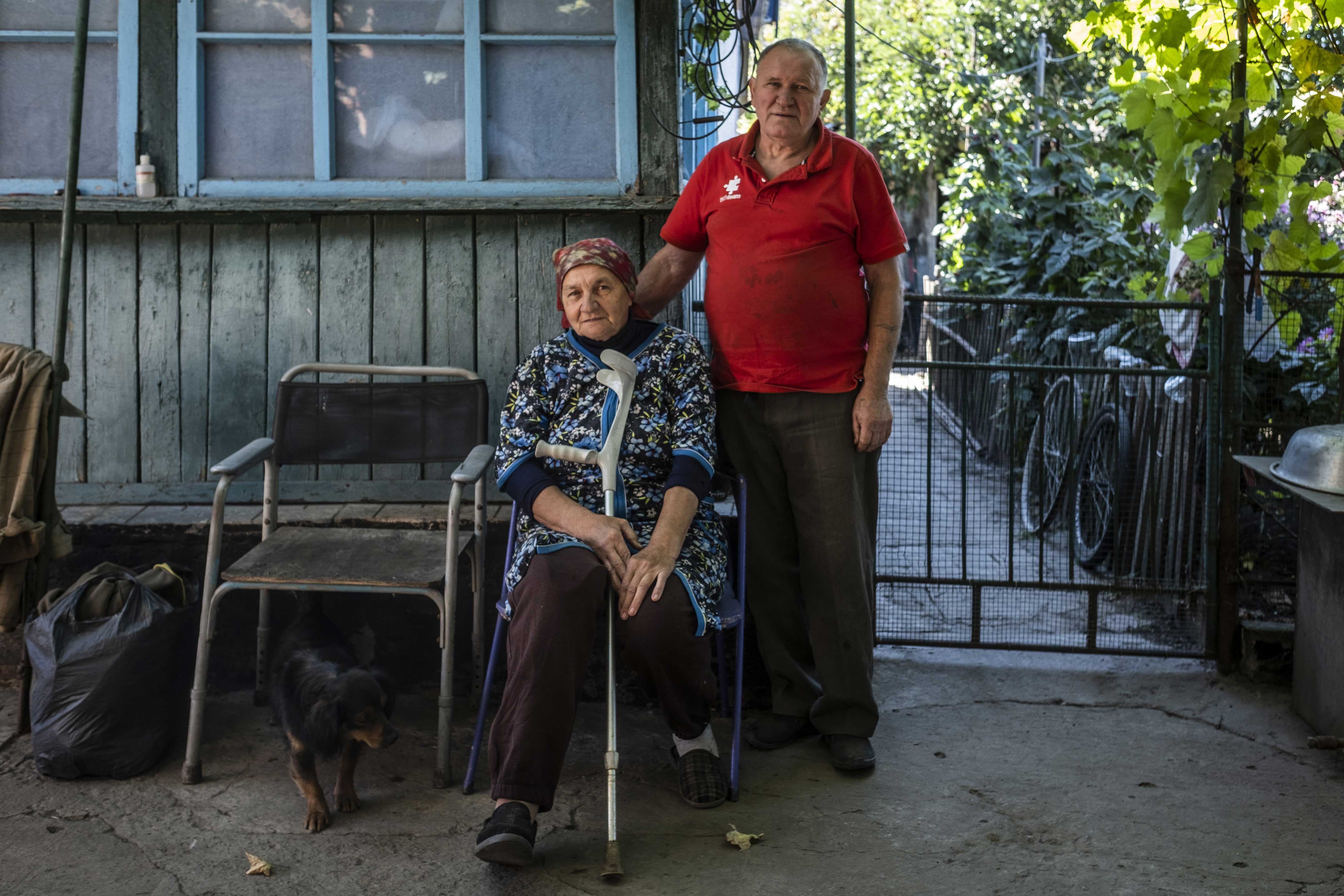Vasyl et Tatiana posent dans la cour de leur maison endommagée par des bombardements,  le 25 septembre 2025.