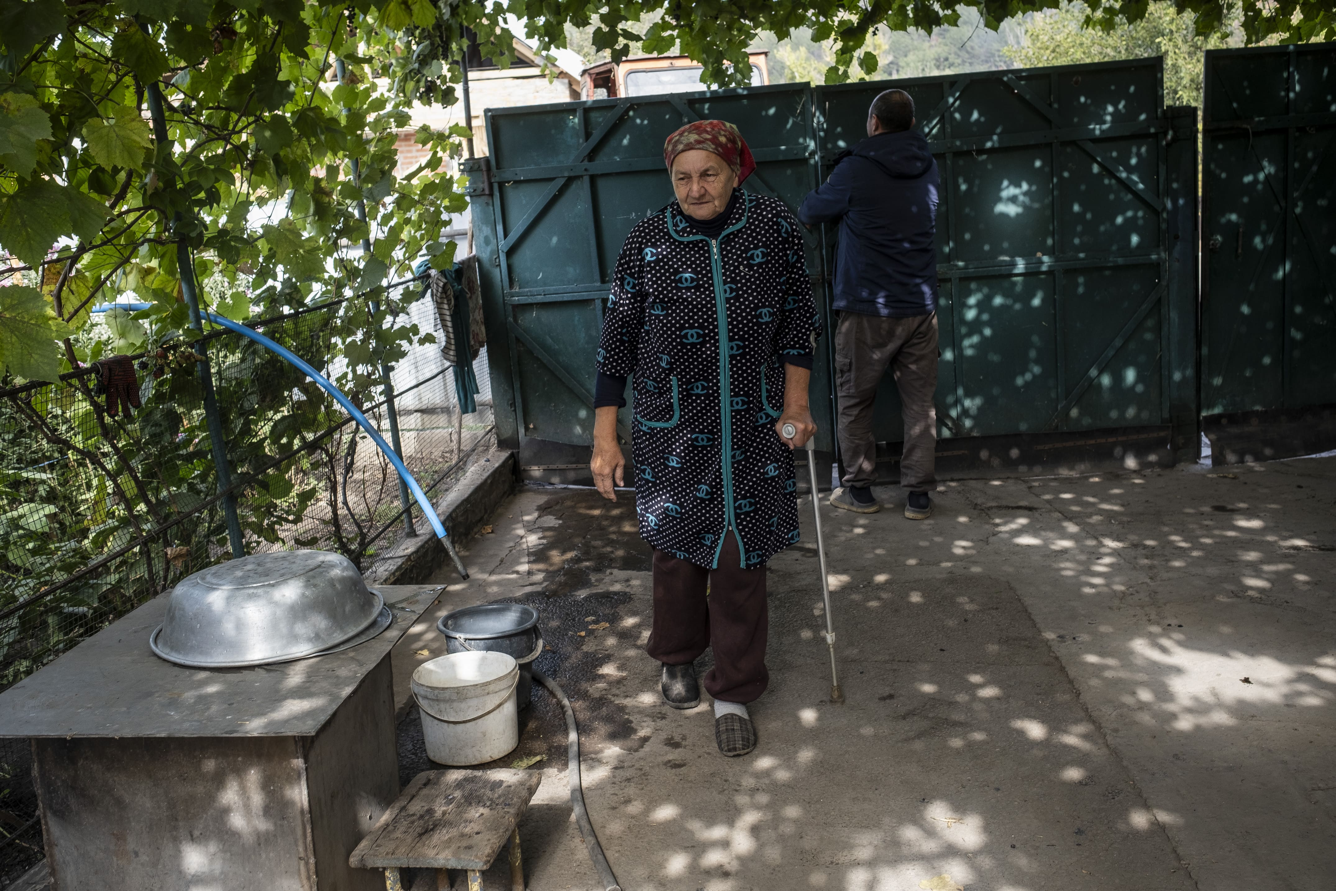 Tatiana, 67 ans, se déplace à l'aide d'une béquille dans la cour de sa maison du village de Kamianka, le 25 septembre 2025. Le 4 juin 2024, jour de son anniversaire, elle a marché sur une mine antipersonnel PFM-1 