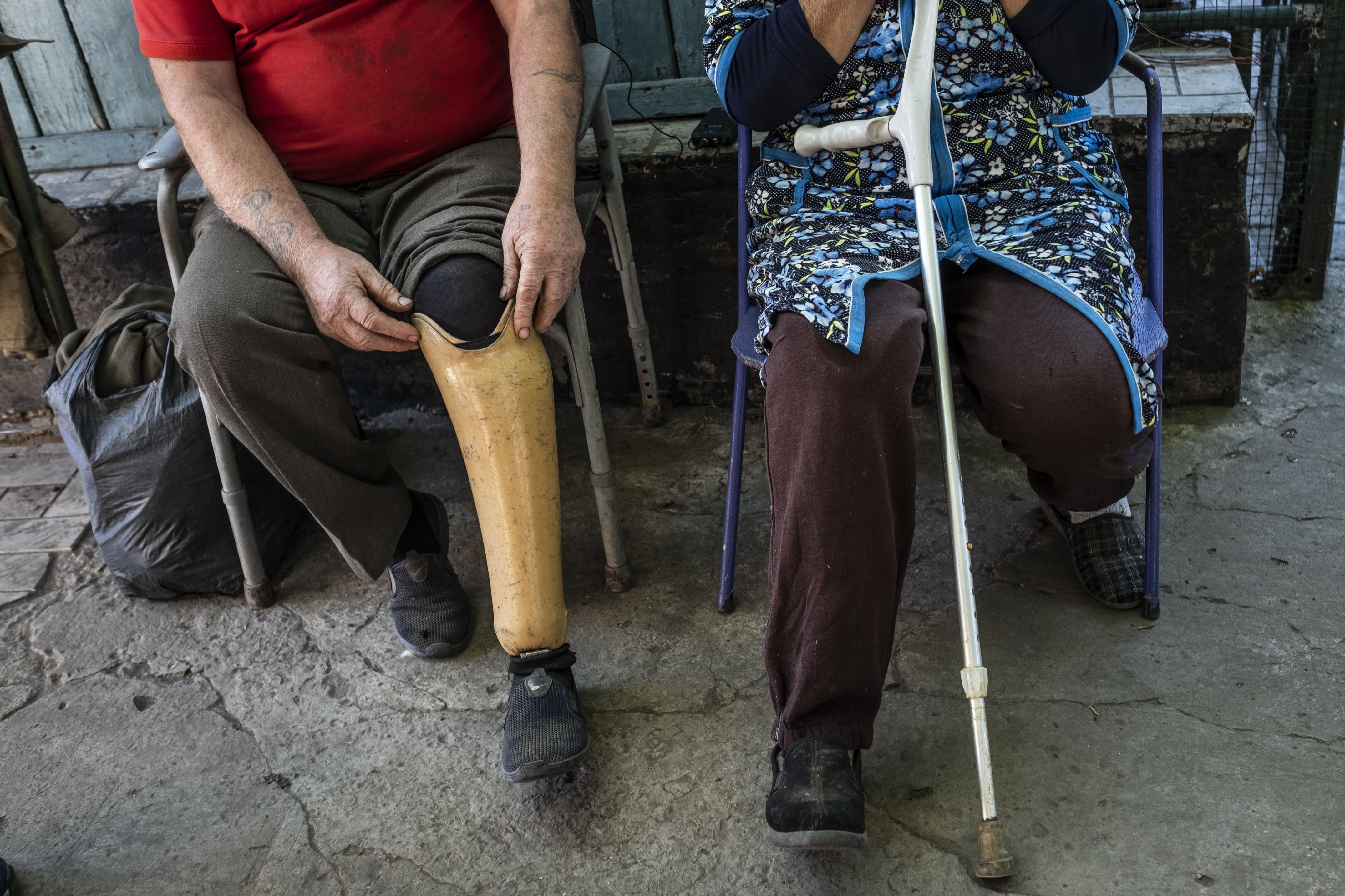 Vasyl et Tatiana montrent leur jambe amputée dans la cour de leur maison endommagée par les bombardements, le 25 septembre 2025.
