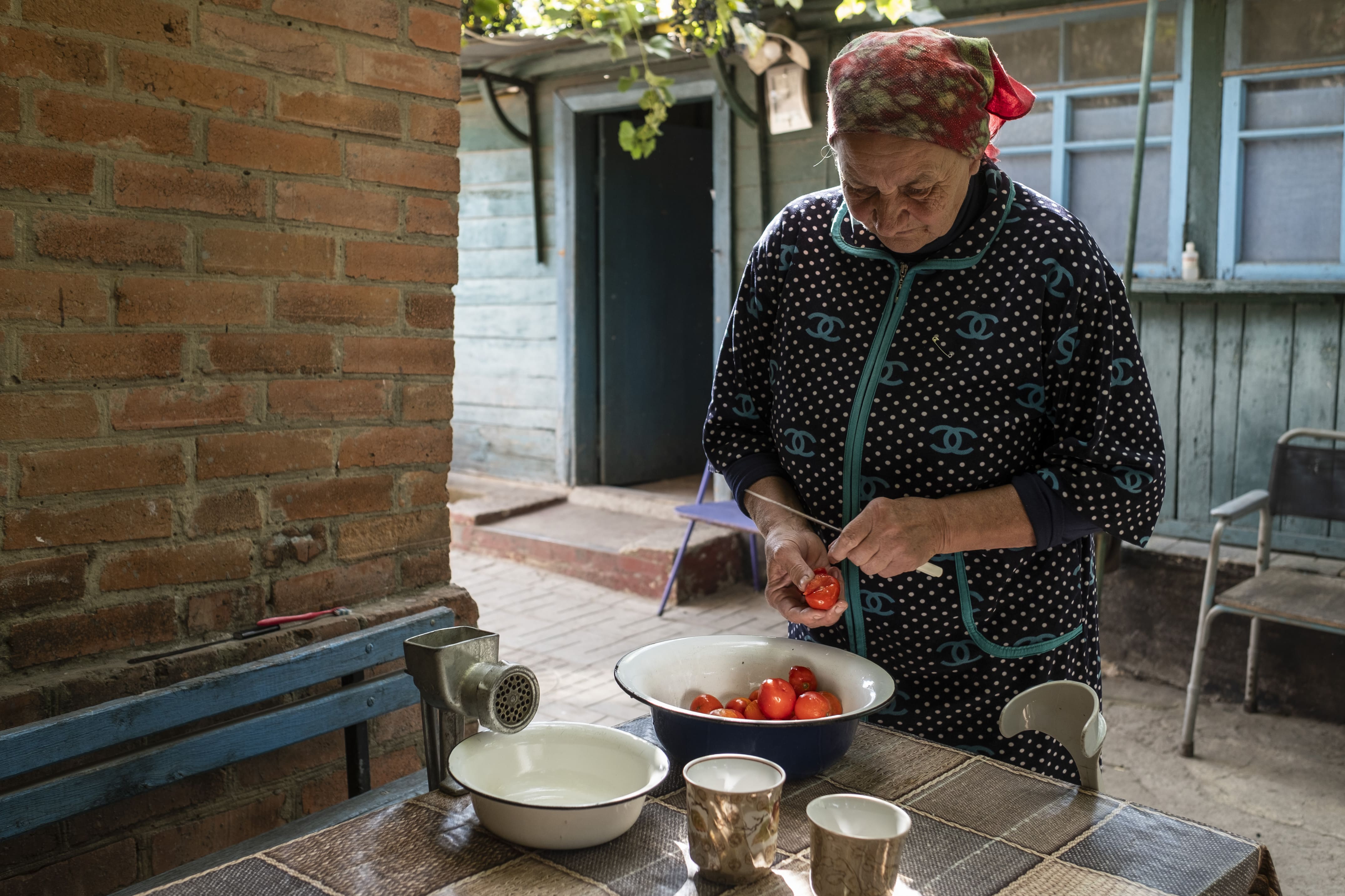 Tatiana, 67 ans, prépare du jus avec des tomates de son potager, le 25 septembre 2025.  