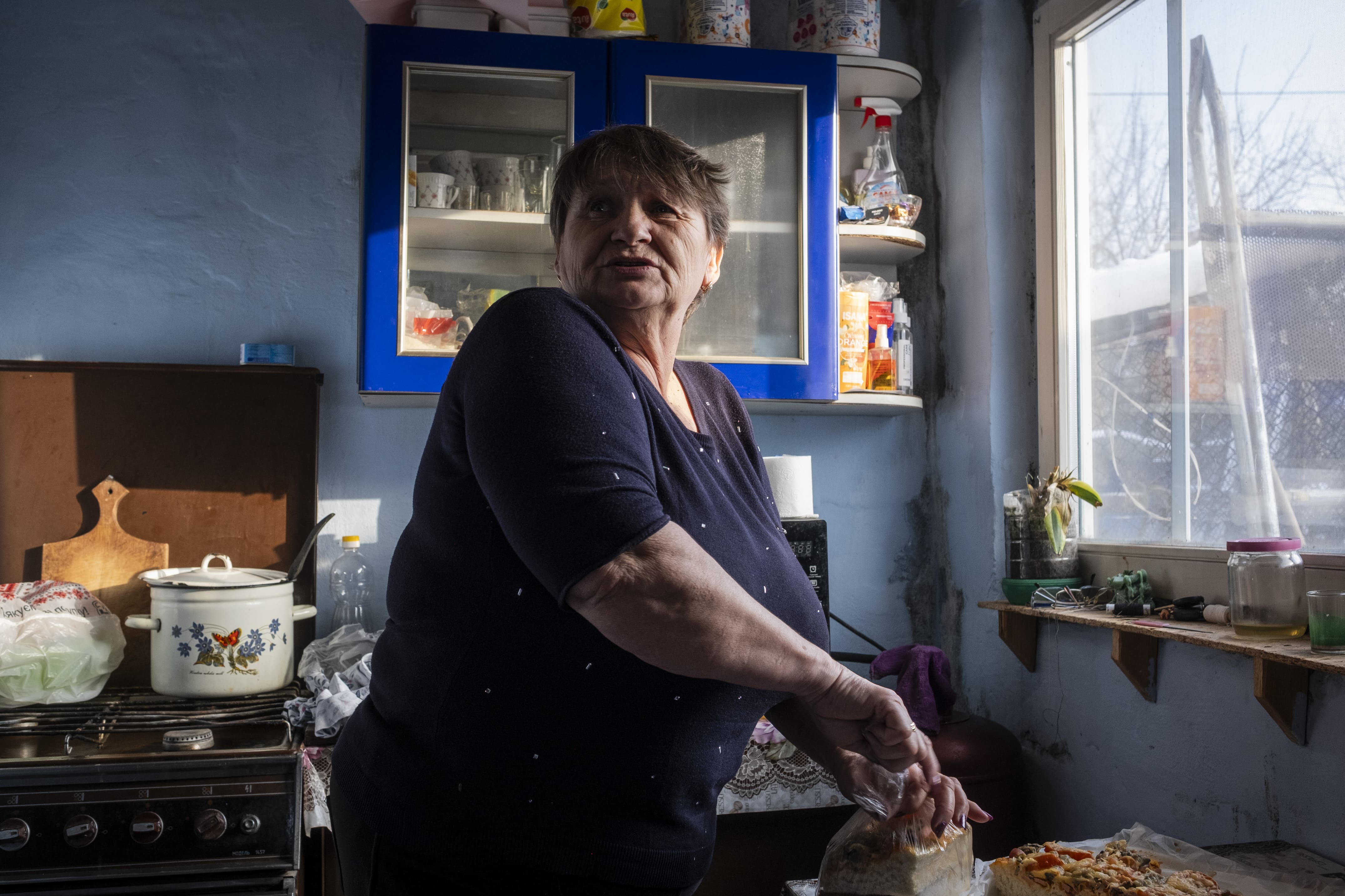 Paulina, 60 ans, la femme de Sergii, emballe des morceaux de pizza dans sa petite cuisine improvisée depuis que sa maison a été détruite au début de la guerre, le 16 janvier 2026.