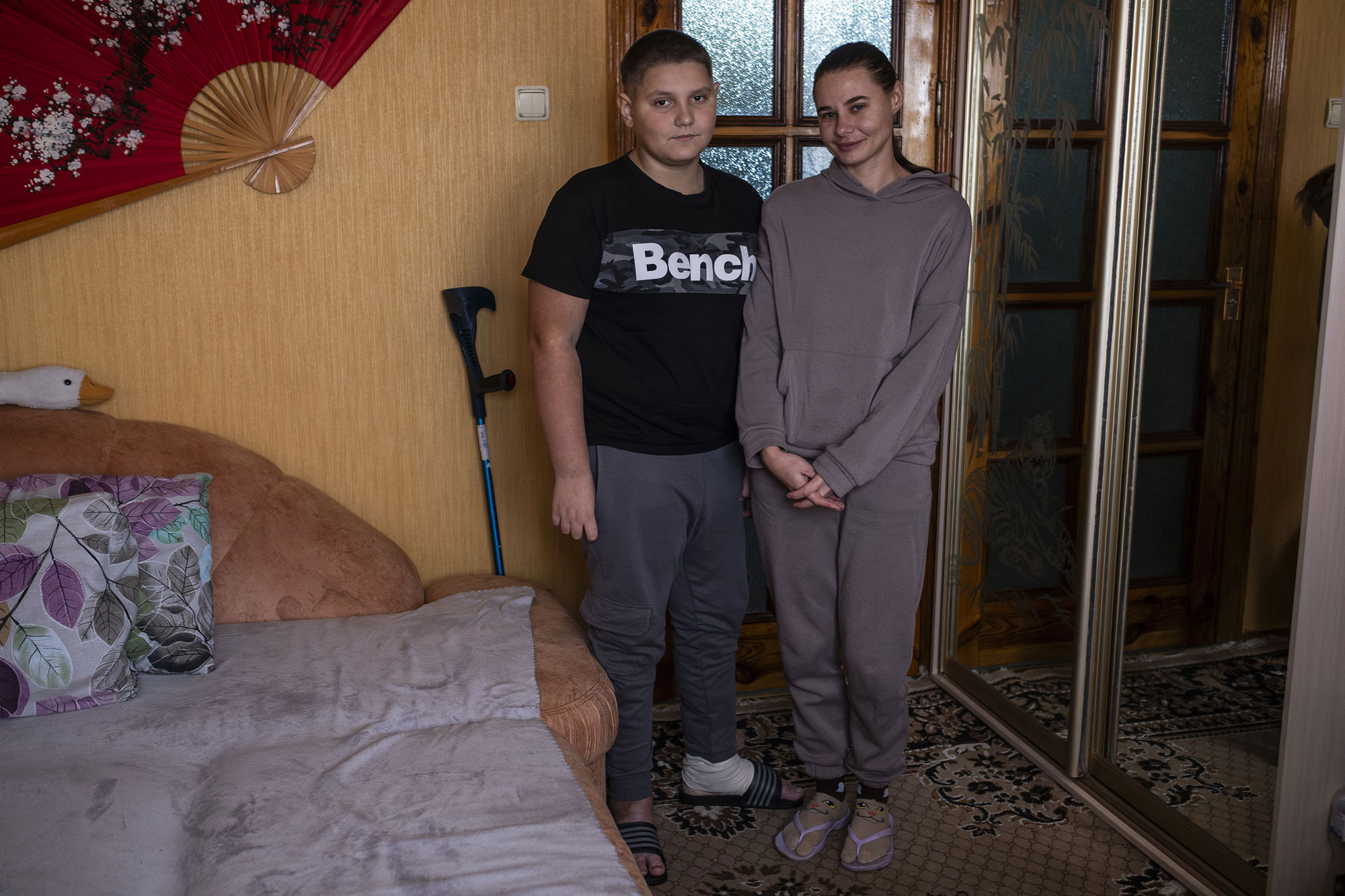Natalia et Zahar posent dans la chambre à coucher de leur appartement à Kharkiv. Zahar est sorti de l’hôpital depuis une semaine et peut maintenant marcher avec des béquilles et se déplacer seul, le 8 octobre 2025.