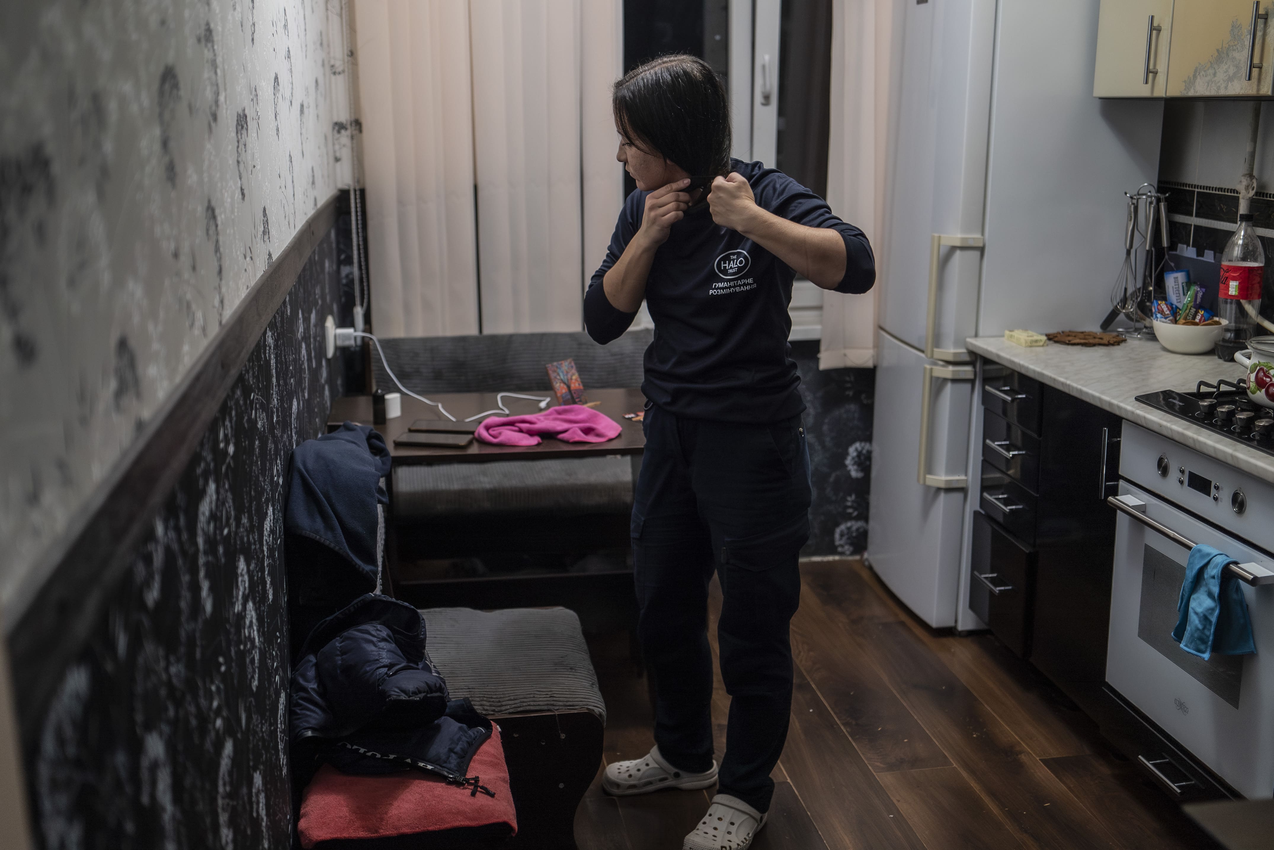 Yelyzaveta s'apprête pour se rendre au travail, le 24 octobre 2025. Chaque jour, Lyza se lève à 4h20 pour être prête à 5h50. Elle quitte son appartement et retrouve son collègue habitant dans le même quartier pour marcher jusqu' au point de rendez-vous et prendre le minibus du HALO Trust.