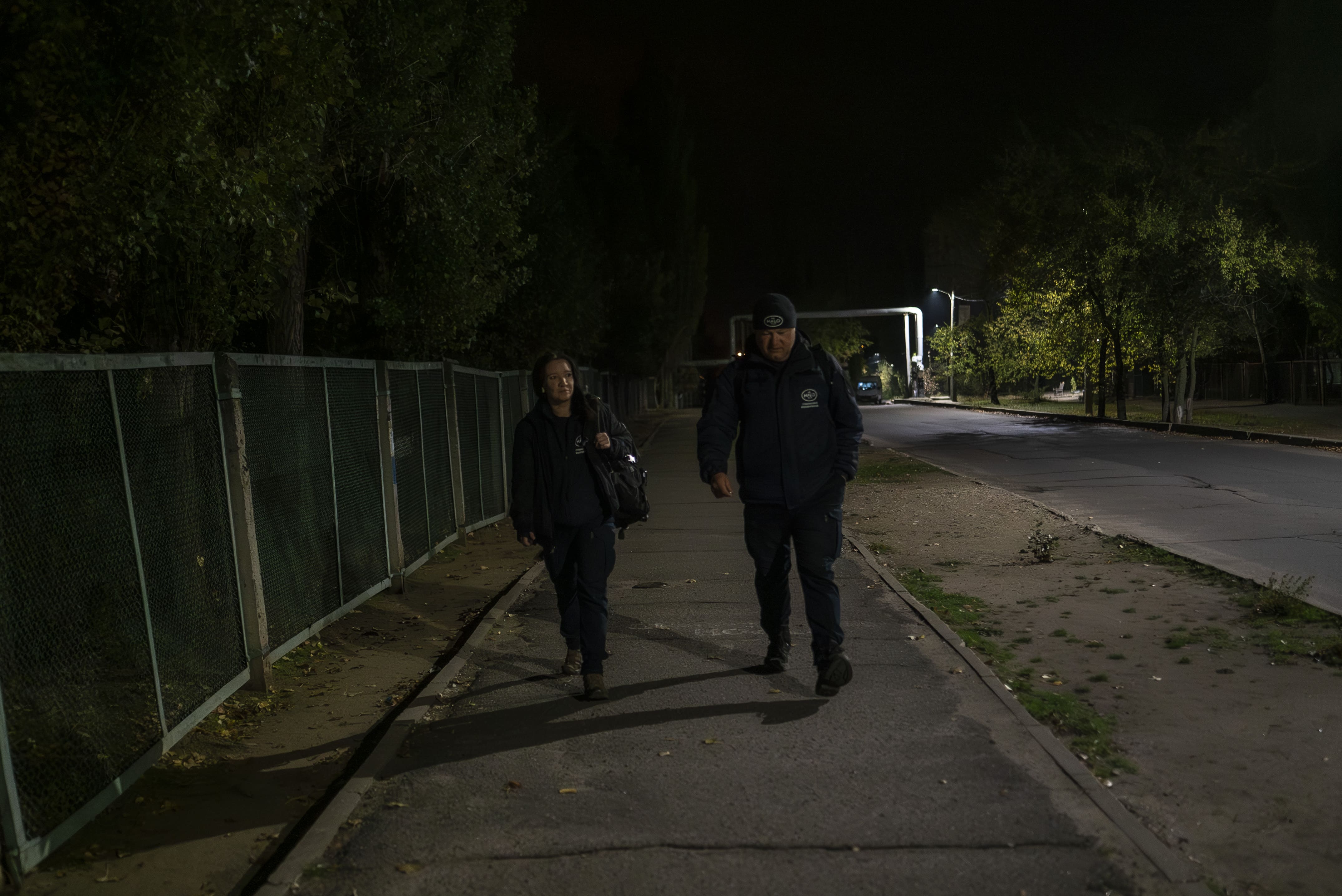Lyza et son collègue du HALO Trust se rendent au point de rendez-vous avec les autres démineurs du quartier, le 24 octobre 2025.