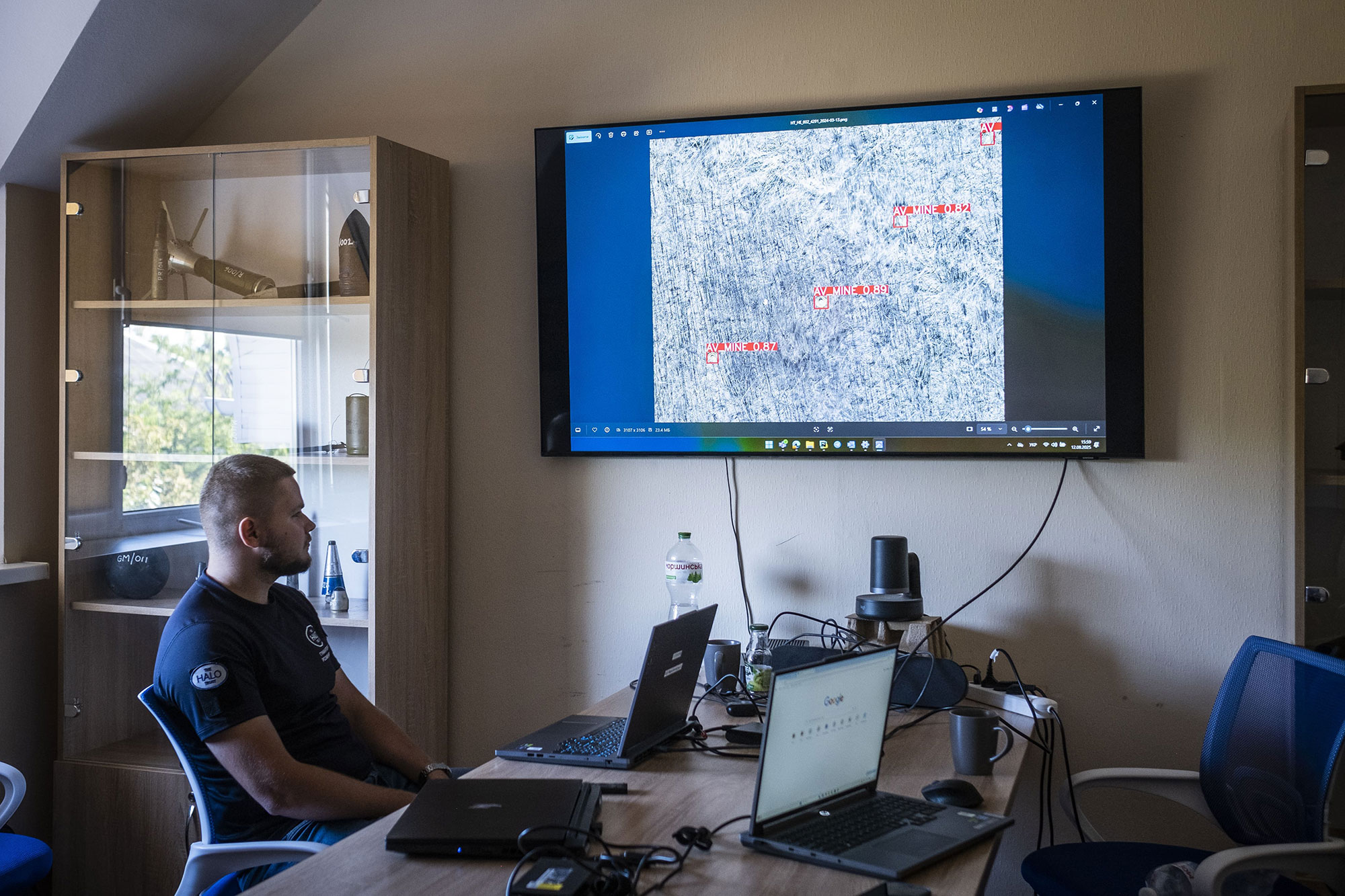 Dans le quartier général du HALO Trust à Mykolaïv, un membre de l’équipe de télédétection montre une image de drone et les mines qui ont été repérées par l’intelligence artificielle, le 12 août 2025.