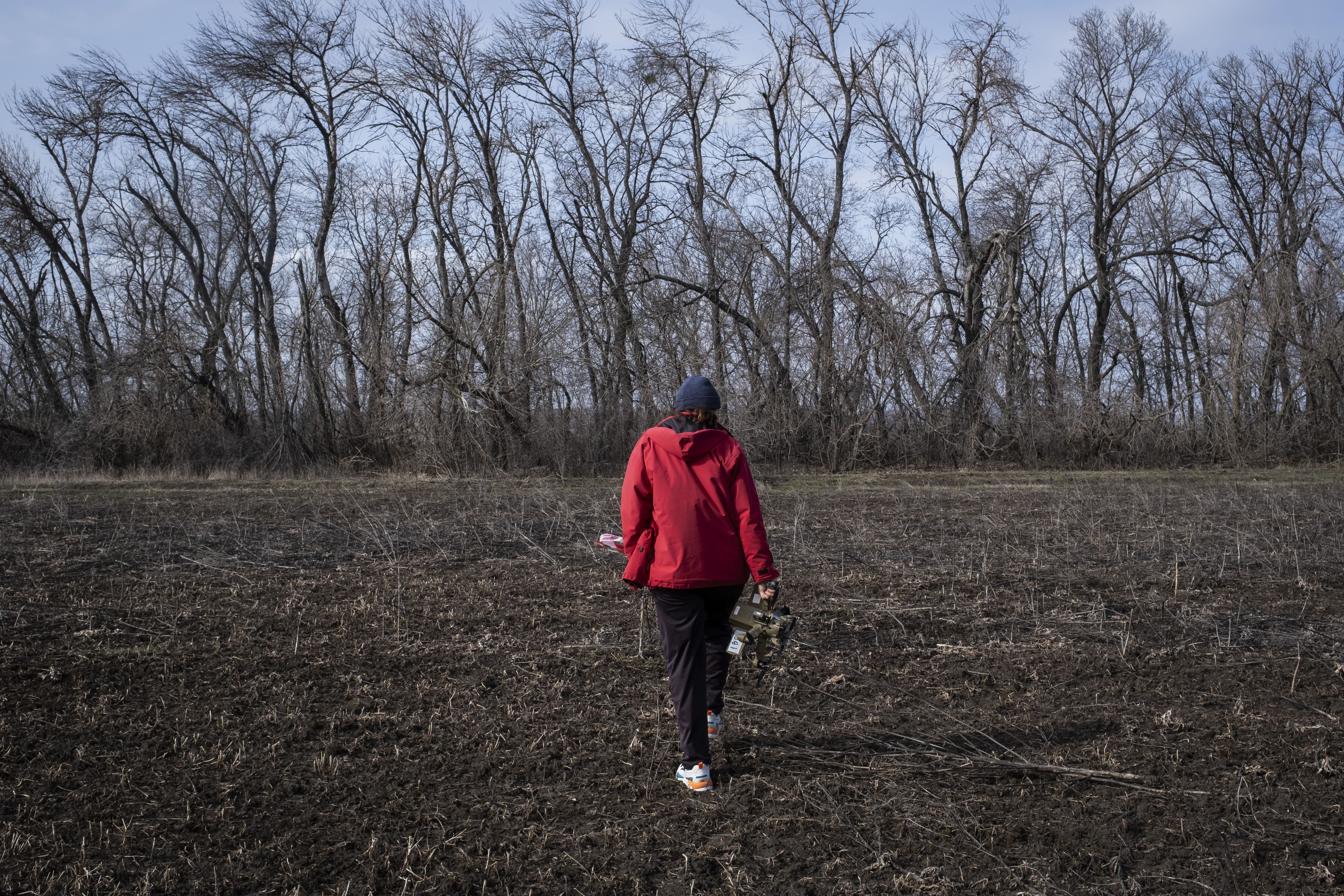 Liudmila dans un de ses champs contaminés, le 16 mars 2026.