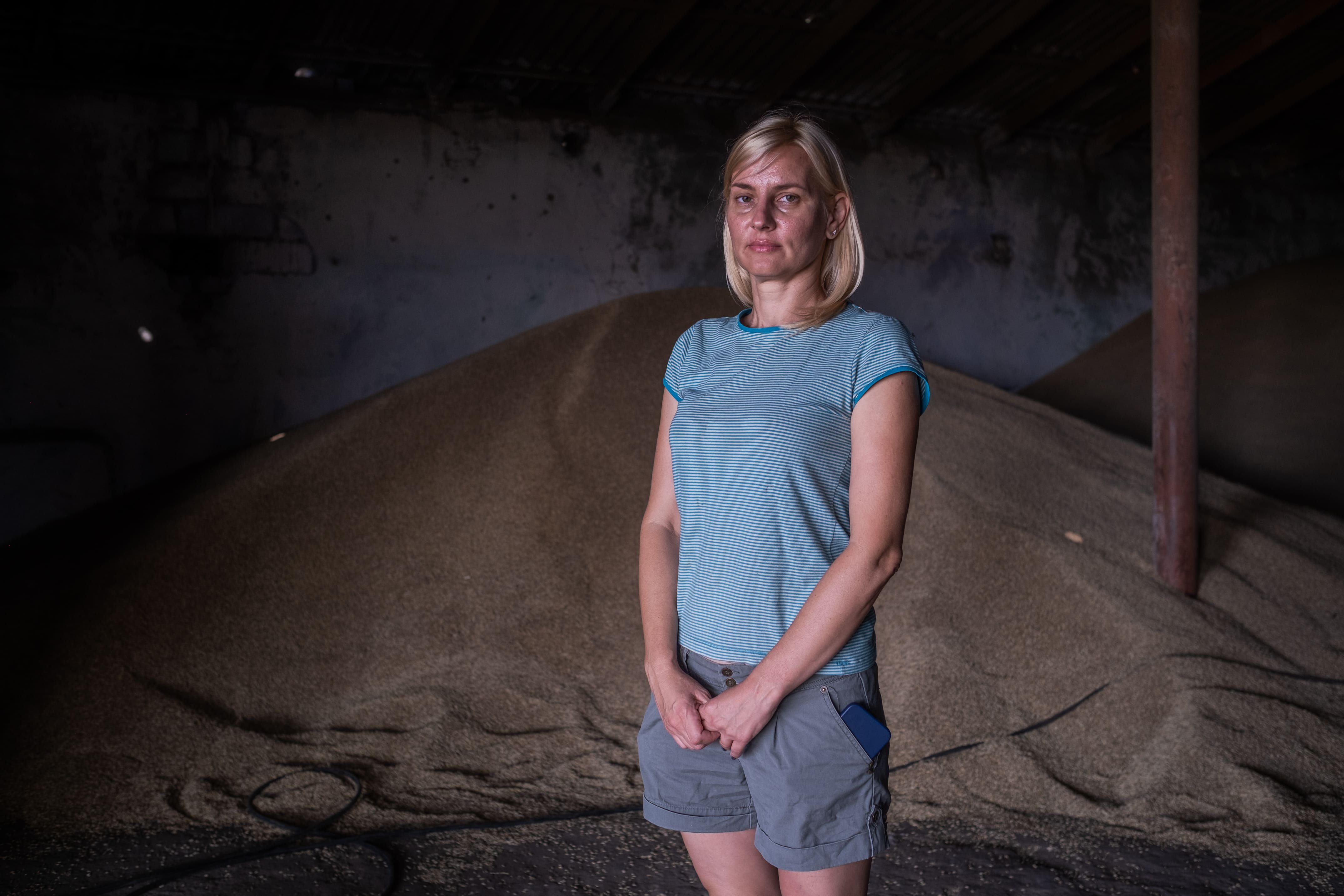 Olena, exploitante agricole de 42 ans dans la région de Mykolaïv, pose devant une partie de ses grains, le 3 août 2023.