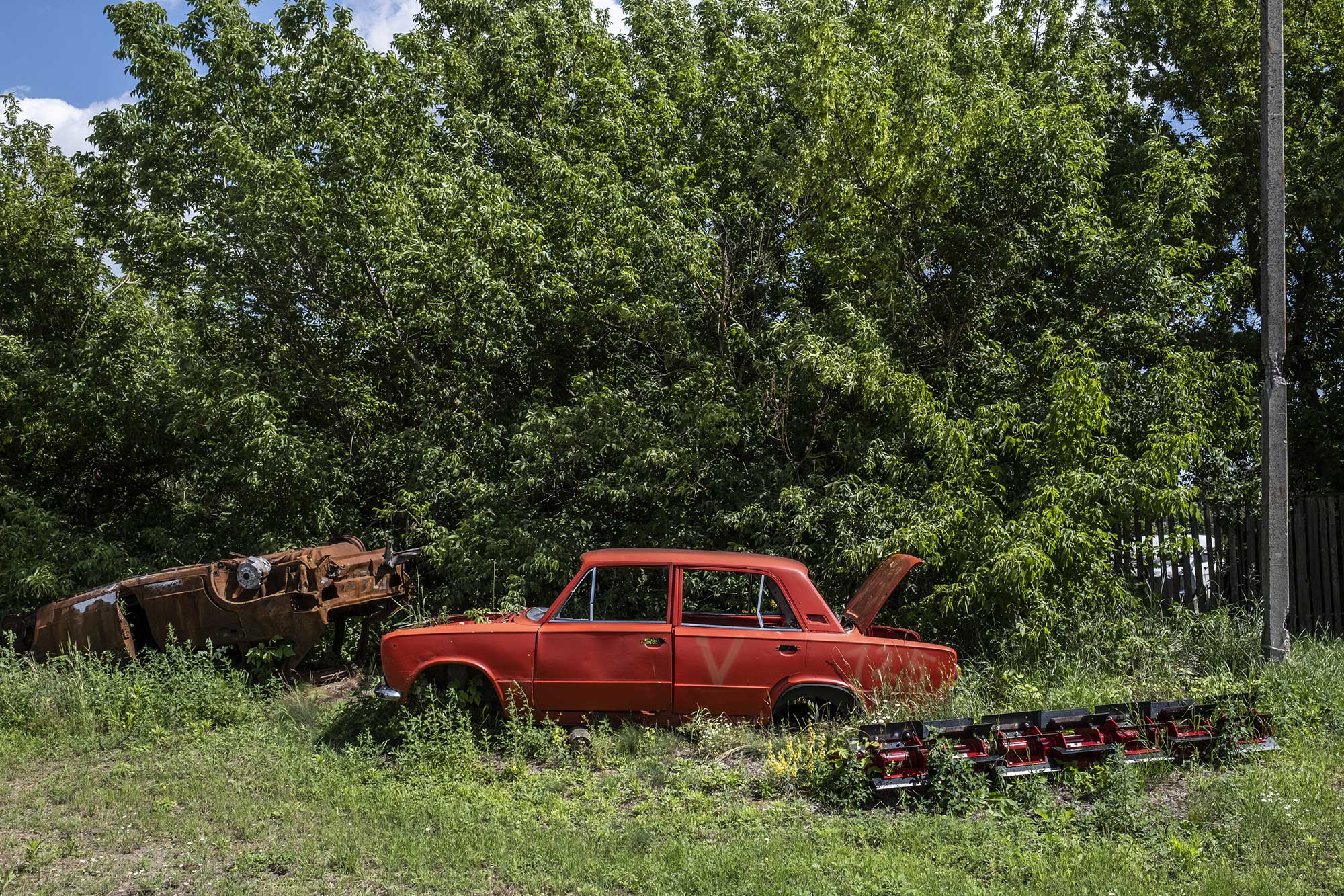 Des carcasses de voitures, dont l’une est marquée d’un “V”, symbole de l’armée russe, gisent devant la maison de Sergii Kohan, le 30 juin 2025.